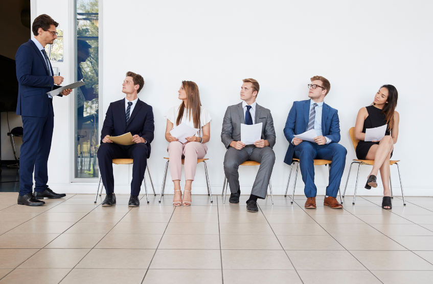 Quattro candidati seduti in attesa di colloquio